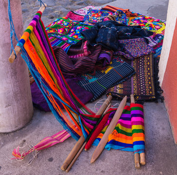Loom on street corner with vibrant colored yarns and clothing