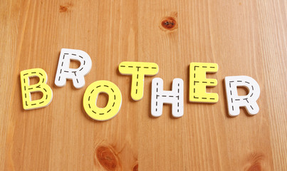 BROTHER, spell by woody puzzle letters with woody background