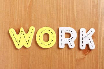 WORK, spell by woody puzzle letters with woody background