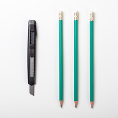 Three pencils with a cutter, isolated on white background
