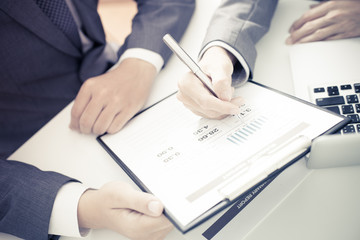 Two businessmen looking at report and having a discussion in off