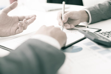 Two businessmen looking at report and having a discussion in off