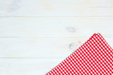 Red towel over wooden kitchen table. View from above with copy s