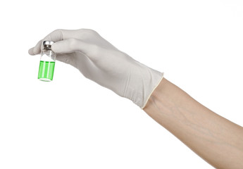 doctor's hand in a white glove holding a green vial of liquid
