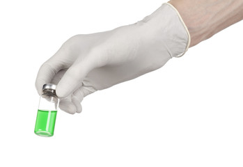 doctor's hand in a white glove holding a green vial of liquid