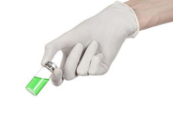 doctor's hand in a white glove holding a green vial of liquid