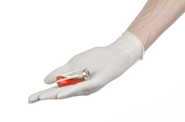 doctor's hand in a white glove holding a red vial of liquid