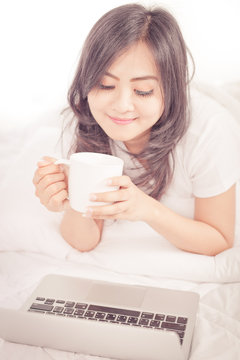 beautiful young woman hold cup of coffee lying think relaxing on