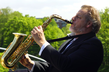 Mann im Smoking spielt Saxophon