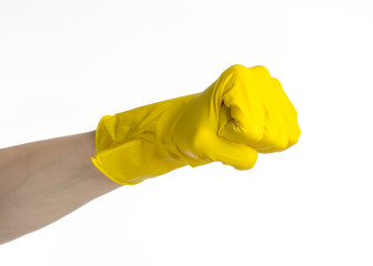 man's hand holding a yellow and wears rubber gloves in studio