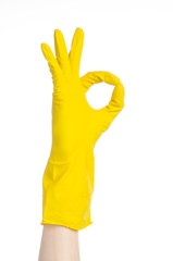man's hand holding a yellow and wears rubber gloves in studio