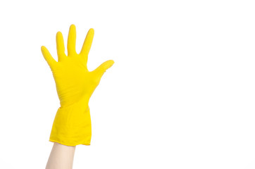 human hand holding a blue toilet brush in yellow gloves