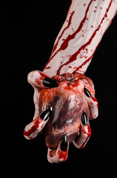 bloody hands with black nails holding bloody human heart