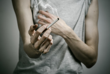 Fototapeta premium smoker holds the cigarette in his hand in the studio