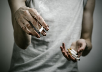 smoker holds the cigarette in his hand in the studio