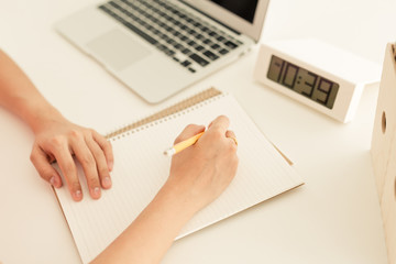 woman using her laptop with clock