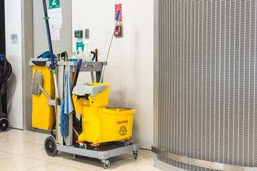 Yellow mop bucket and set of cleaning equipment