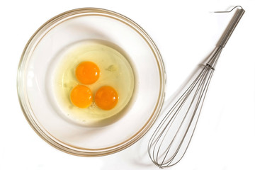 Three eggs in a bowl and whisk for whipping