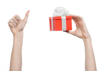 hand holding a gift wrapped in red box with white ribbon and bow
