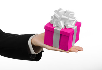 hand holding gift wrapped in pink box with white ribbon and bow