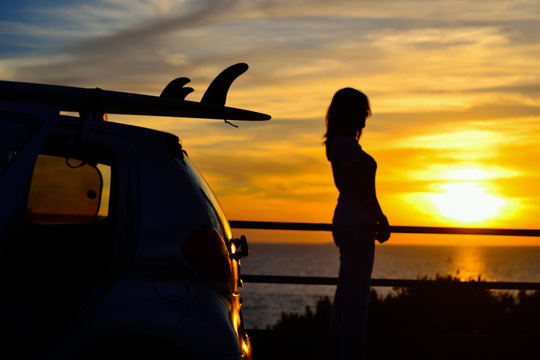 girl and surfboard silhouettes at sunset