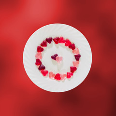 Colored heart shape jellies on a white plate