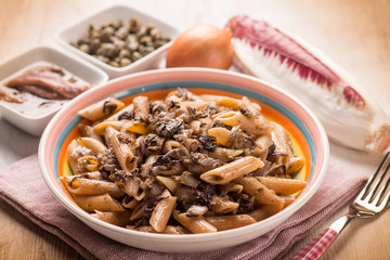 macaroni with red chicory anchovy and capers, selective focus