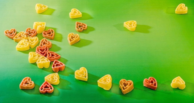 Heart shape pastas on colored background