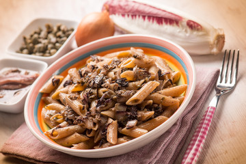 macaroni with red chicory anchovy and capers, selective focus