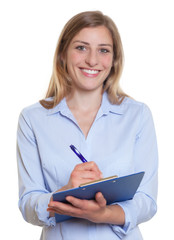 Lachende Businessfrau mit blonden Haaren und Clipboard