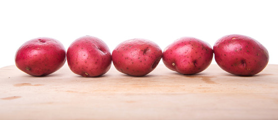 Red potato on wooden surface