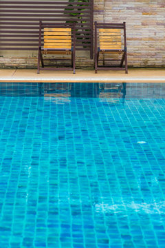 Chair on ground beside swimming pool