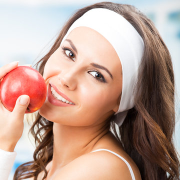 Portrait of young beautiful woman with red apple