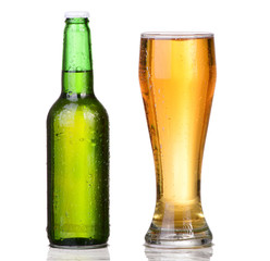 Chilled green bottle with condensate and a glass of beer 