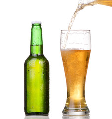 Chilled green bottle with condensate and a glass of beer 