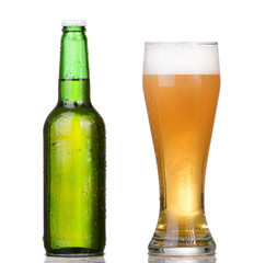 Chilled green bottle with condensate and a glass of beer 