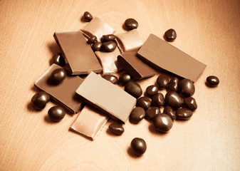 Group of chocolate pieces on wooden background. Vintage style