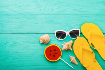Summer accessories and lollipop on blue wooden background
