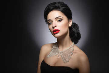 Beautiful woman with evening make-up, red lips and evening hairstyle.
