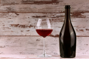 Red wine bottle on a wooden background