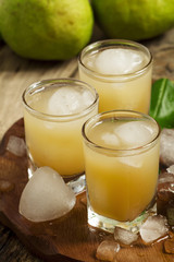 Pear fresh juice with ice in a heart-shaped and pear on a wooden