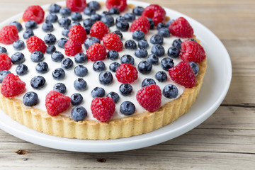Cake with blueberries and raspberries. Confectionery product.