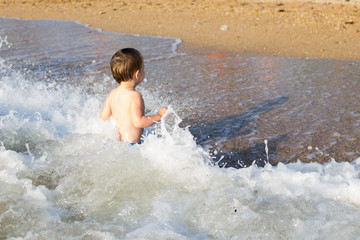 a little boy having fun in the sea on the waves
