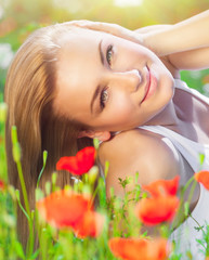 Obraz na płótnie Canvas Beautiful woman on poppy flower field