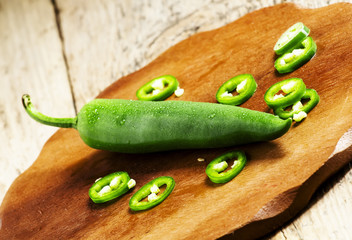 Spicy green pepper on a wooden cutting board, selective focus