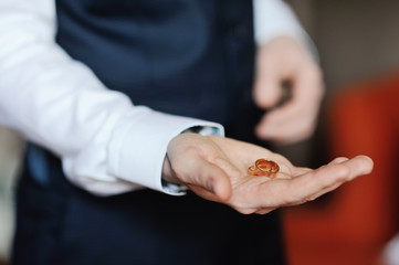 groom holding a wedding ring