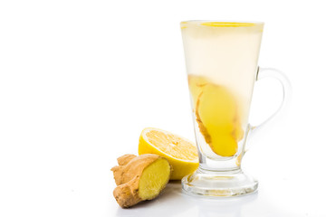 Hot ginger and lemon tea in transparent tall glass