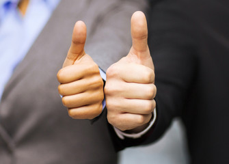 businessman and businesswoman showing thumbs up