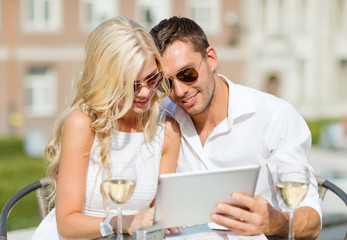 couple looking at tablet pc in cafe