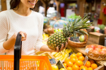 close up of woman with pineapple in grocery market